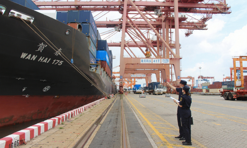 Two customs officers check a cargo ship at the Haitian Container Terminal of Xiamen Port, East China's Fujian Province, on August 6, 2025. Photo: Courtesy of Dongdu Customs